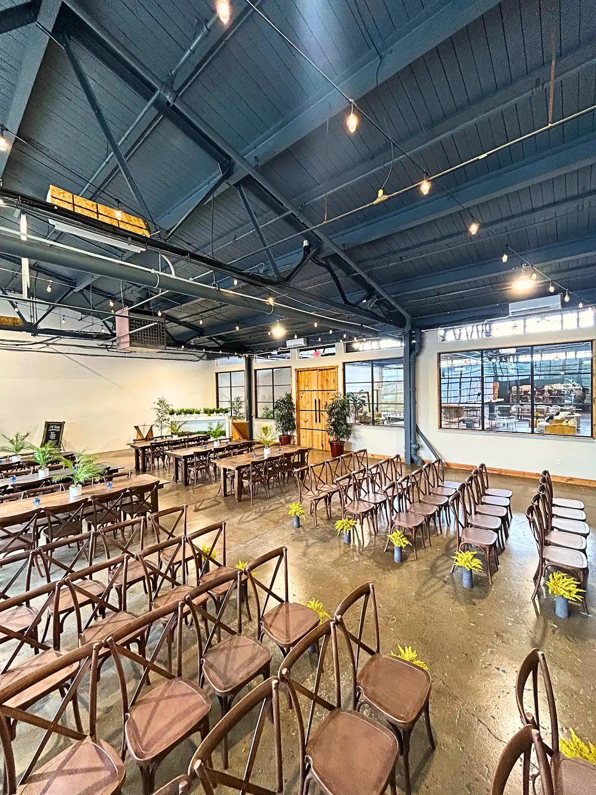 Tall factory windows and industrial ceiling inside The VV Showroom